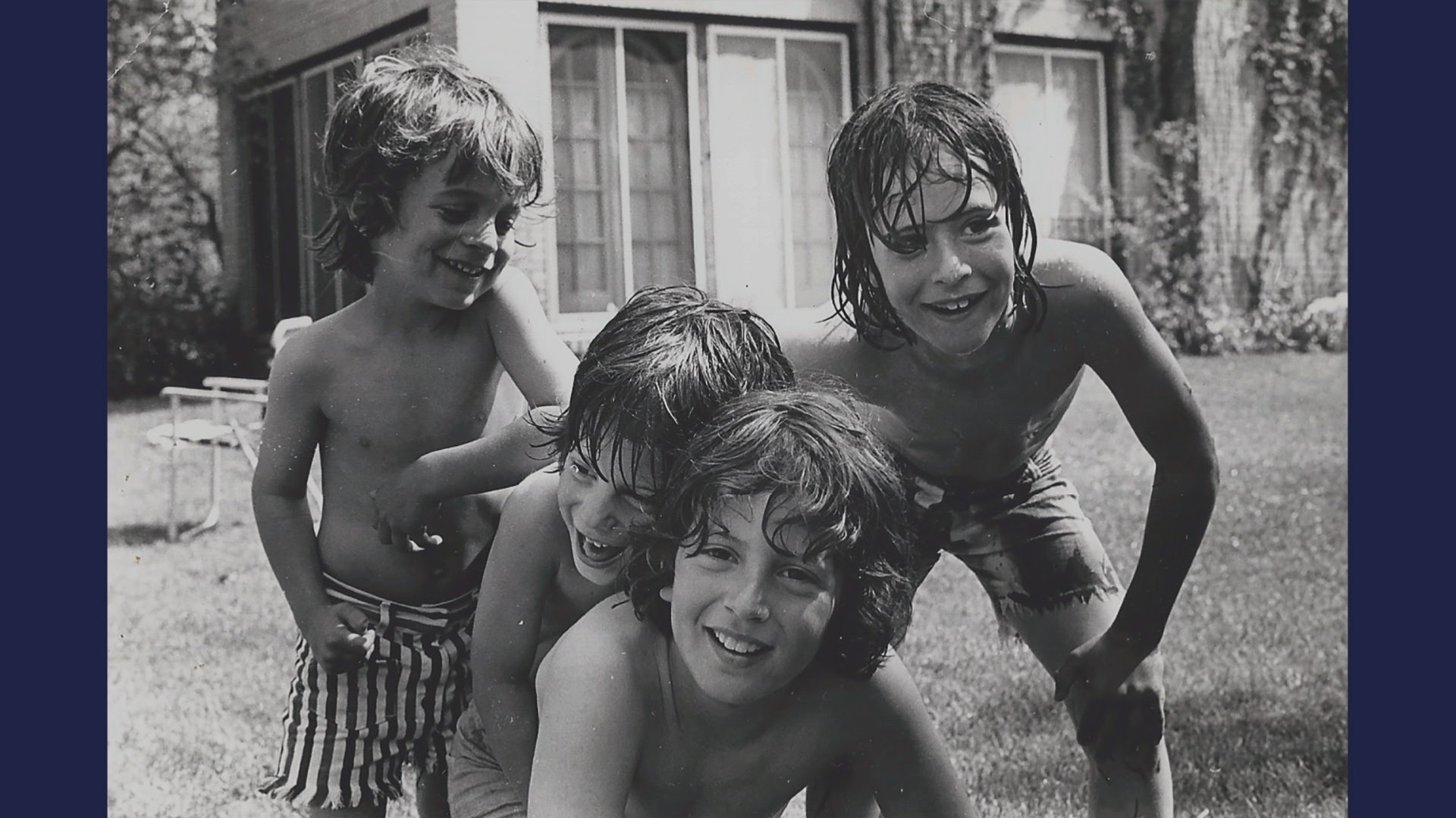 Adam and David Rudman, along with their two brothers, play in the backyard of their family home as kids.