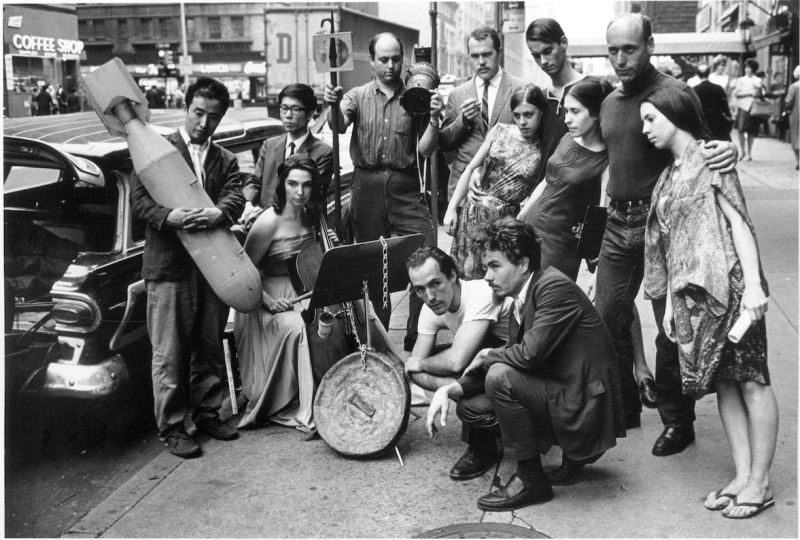 Publicity photograph for 3rd Annual New York Avant-Garde Festival, August 26, 1965. Left to right: Nam June Paik, Charlotte Moorman, Takehisa Kosugi, Gary Harris, Dick Higgins, Judith Kuemmerle, Kenneth King, Meredith Monk, Al Kurchin, Phoebe Neville. In front, kneeling, Philip Corner and James Tenney. (Photo, Peter Moore. Photograph © Barbara Moore/Licensed by VAGA, NY)
