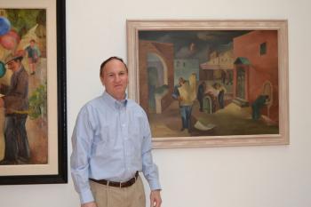 Nathan Harpaz, Manager and Curator of the Koehnline Museum of Art, stands in front of his favorite painting displayed in the exhibit, Hull House Courtyard (1930-1931)