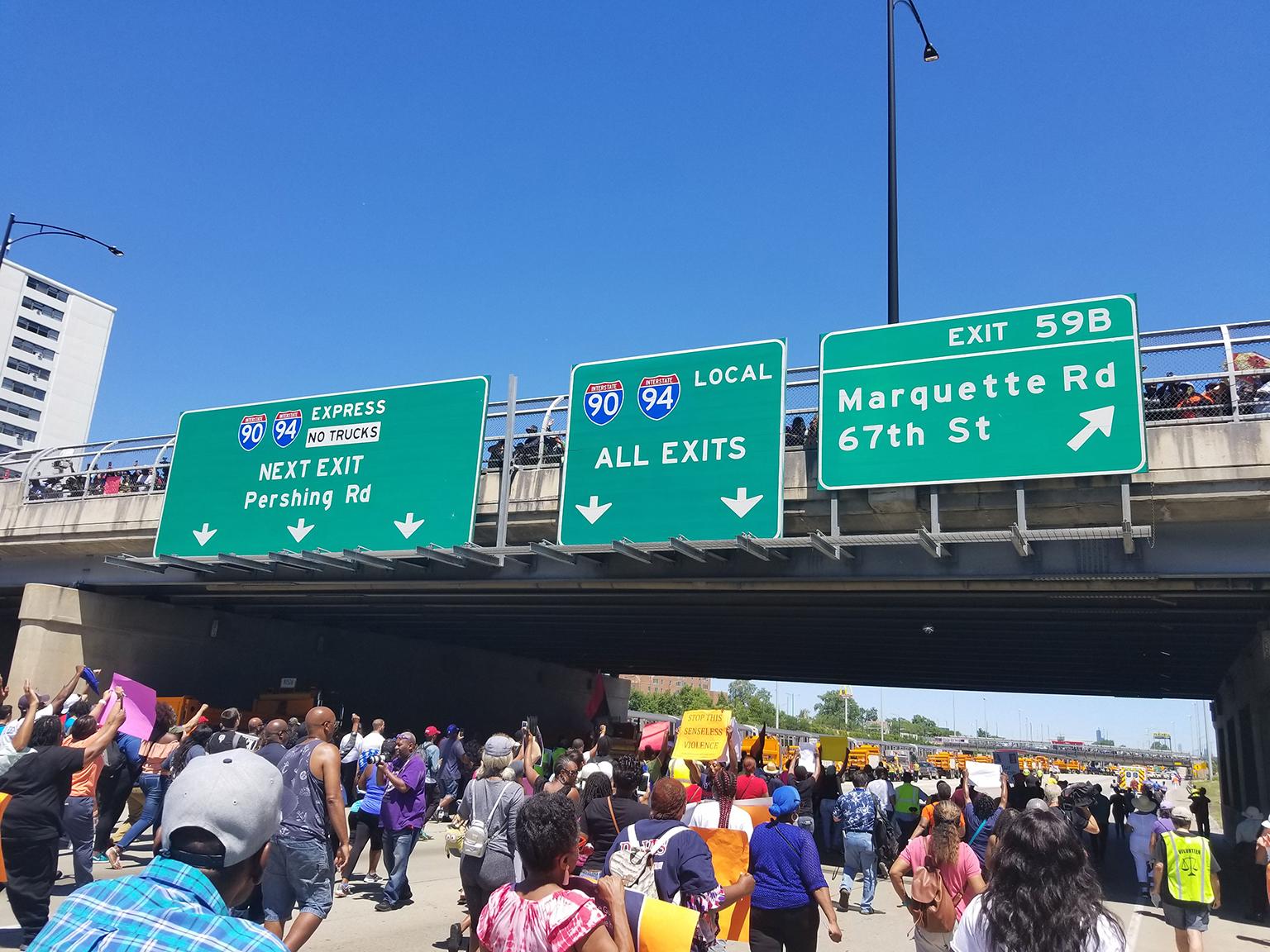 Protesters move into the home stretch Saturday under a 71st Street overpass filled with hundreds more onlookers. (Matt Masterson / Chicago Tonight)
