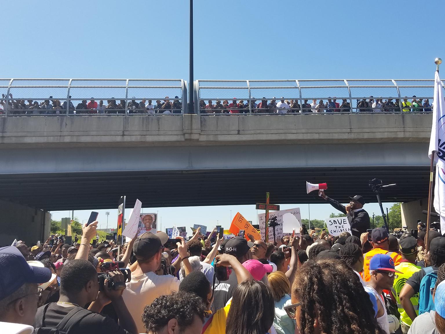 Protesters pause at the 76th Street overpass on the Dan Ryan Expressway on July 7, 2018. (Matt Masterson / Chicago Tonight)