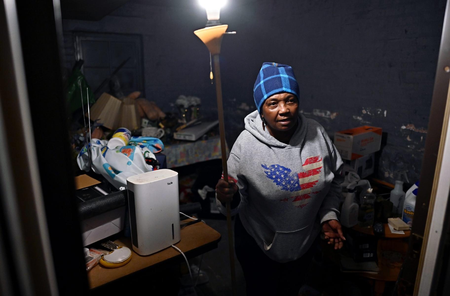 Mary Buchanan, who lives in West Garfield Park, goes through some of the belongings that she was able to save after her basement last year. March 21, 2024. (Victor Hilitski / Illinois Answers Project)