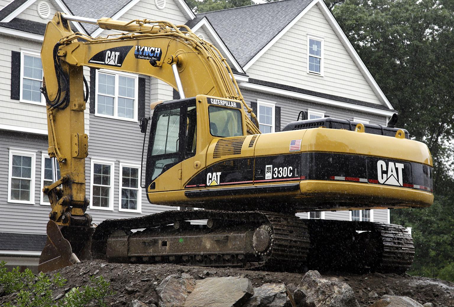 In this July 24, 2017 file photo, a Caterpillar excavator rests at a housing construction site in North Andover, Mass. Caterpillar Inc. reports earnings Tuesday, Oct. 23, 2018. (AP Photo / Elise Amendola, FIle)