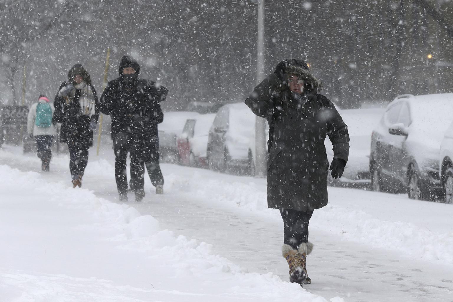 Commuters walk to a bus stop as snow falls, Monday, Nov. 26, 2018, in Chicago. (Kiichiro Sato / AP Photo)
