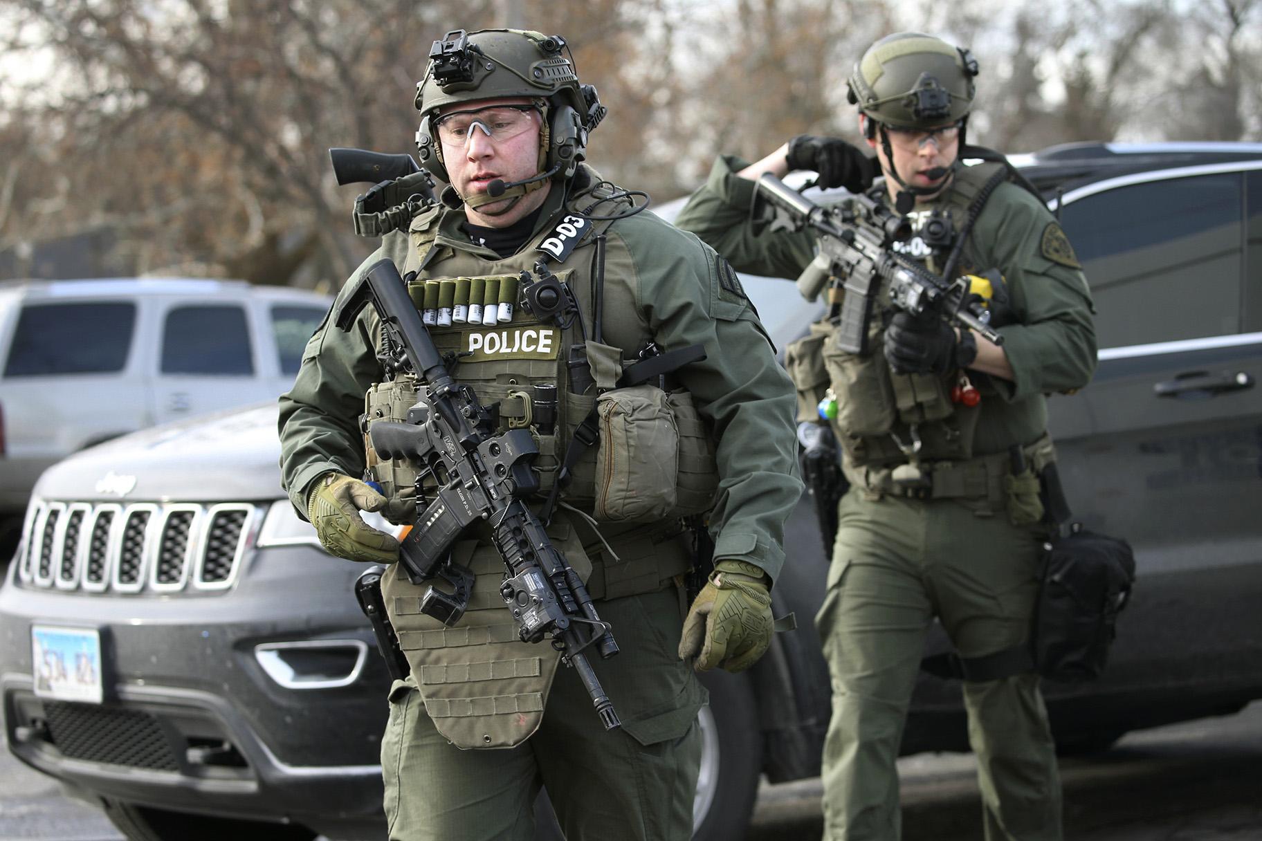 Police officers armed with rifles gather at the scene where an active shooter was reported in Aurora, Illinois, on Friday, Feb. 15, 2019. (Antonio Perez / Chicago Tribune via AP)