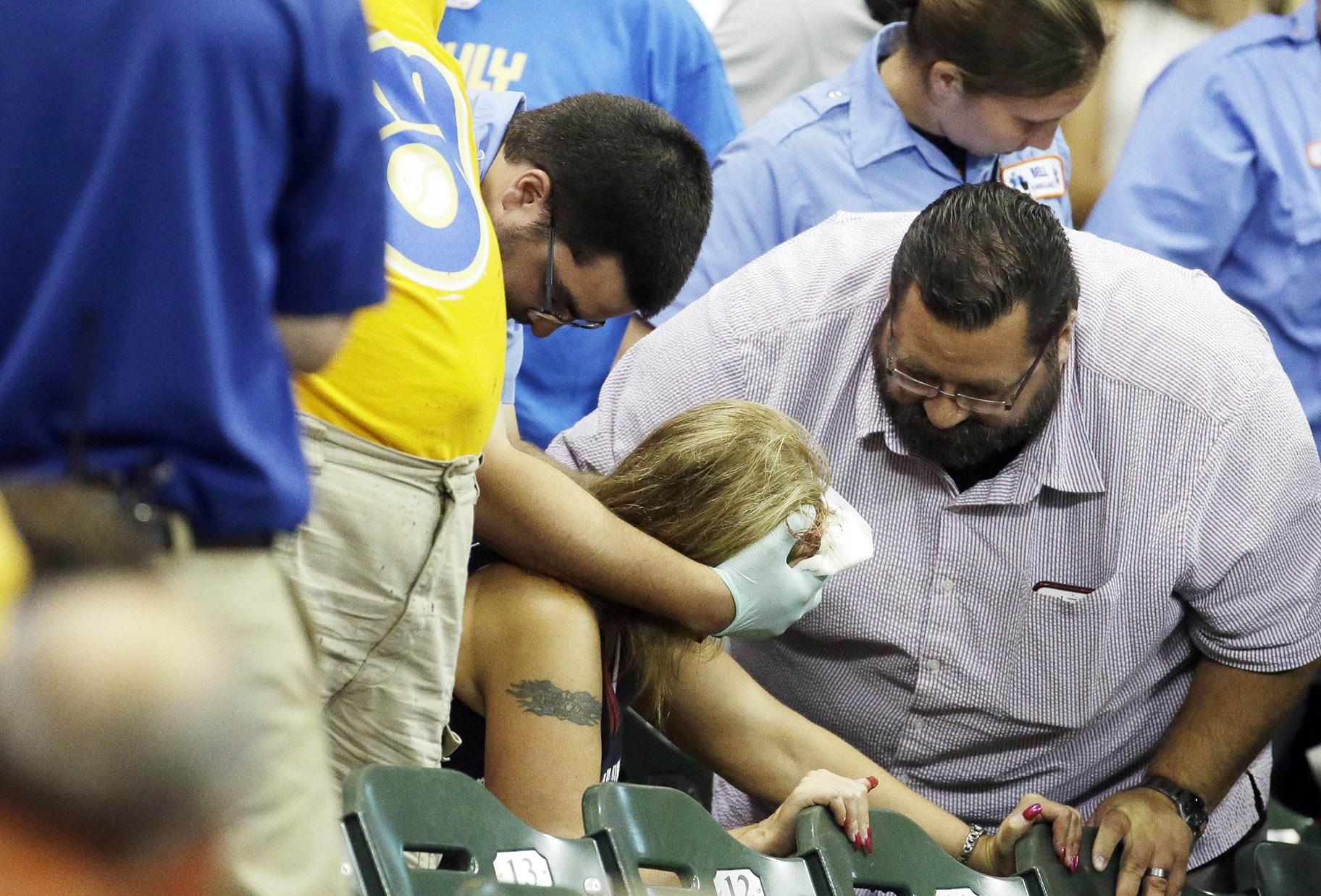In this July 6, 2015 file photo, a fan is helped after being hit by a foul ball during the ninth inning of a baseball game between the Milwaukee Brewers and the Atlanta Braves in Milwaukee. (AP Photo / Morry Gash, File)
