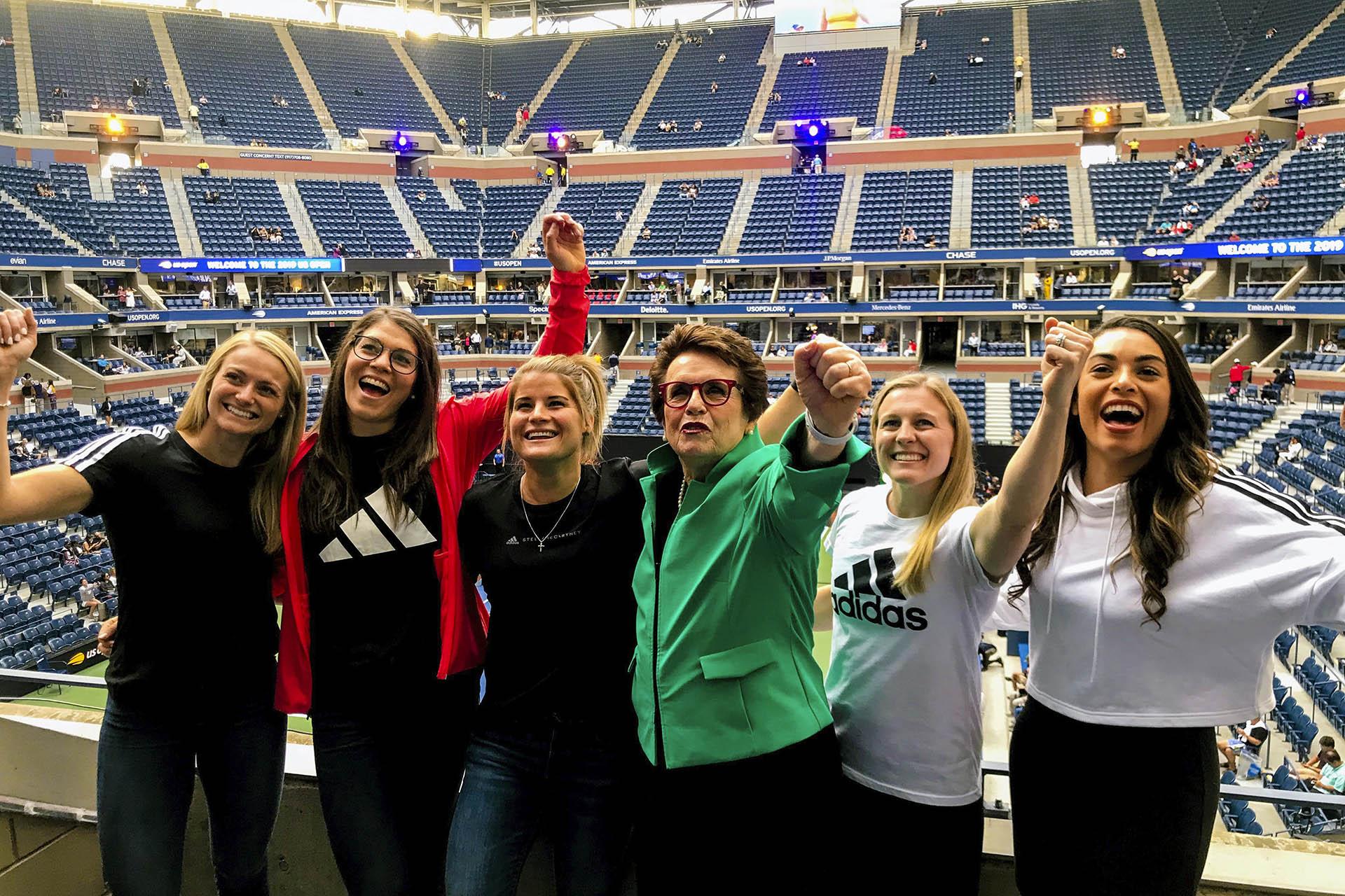 In this image provided by Adidas, Hall of Fame tennis player Billie Jean King, center, poses with hockey players, from left, Canadian Renata Fast, Canadian Rebecca Johnston, American Brianna Decker, King, American Kendall Coyne Schofield and Canadian Sarah Nurse at the U.S. Open tennis tournament in New York, Monday, Aug. 26, 2019 (Samantha Hughey / Adidas via AP)