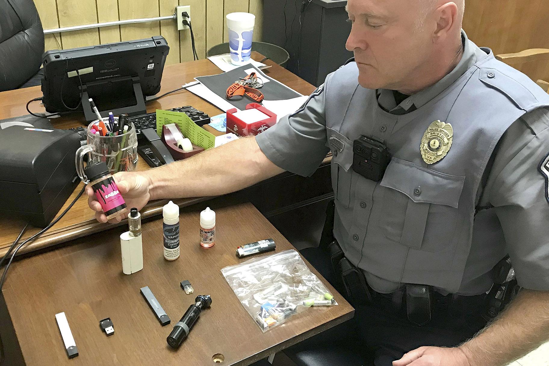 In this Sept. 23, 2019 photo, Bristol, Va., Police Officer Marlin Goff shows some of the vaping products he has confiscated from students at a high school. (Tim Dotson / Bristol Herald Courier via AP)