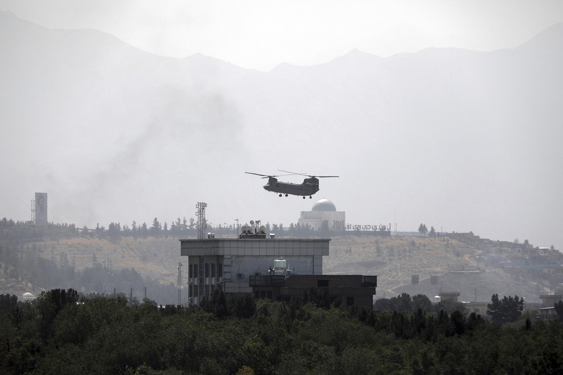 A U.S. Chinook helicopter flies over the U.S. Embassy in Kabul, Afghanistan, Sunday, Aug. 15, 2021. (AP Photo / Rahmat Gul)