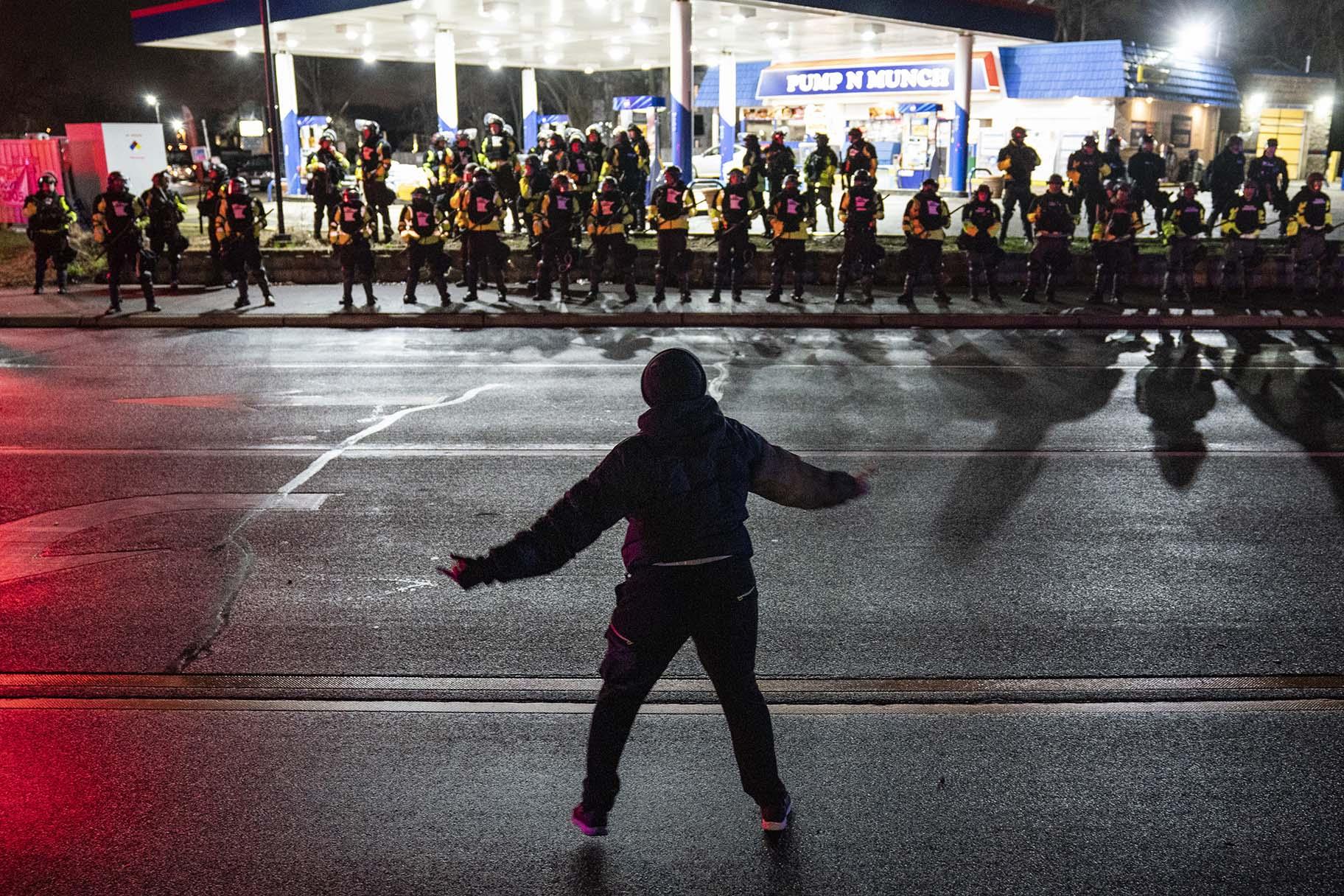 A demonstrator heckles authorities who advanced into a gas station after issuing orders for crowds to disperse during a protest against the police shooting of Daunte Wright, late Monday, April 12, 2021, in Brooklyn Center, Minn. (AP Photo / John Minchillo)