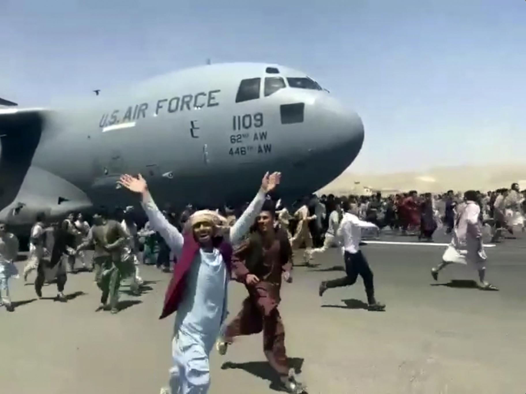 Hundreds of people run alongside a U.S. Air Force C-17 transport plane as it moves down a runway of the international airport, in Kabul, Afghanistan, Monday, Aug.16. 2021. (Verified UGC via AP)