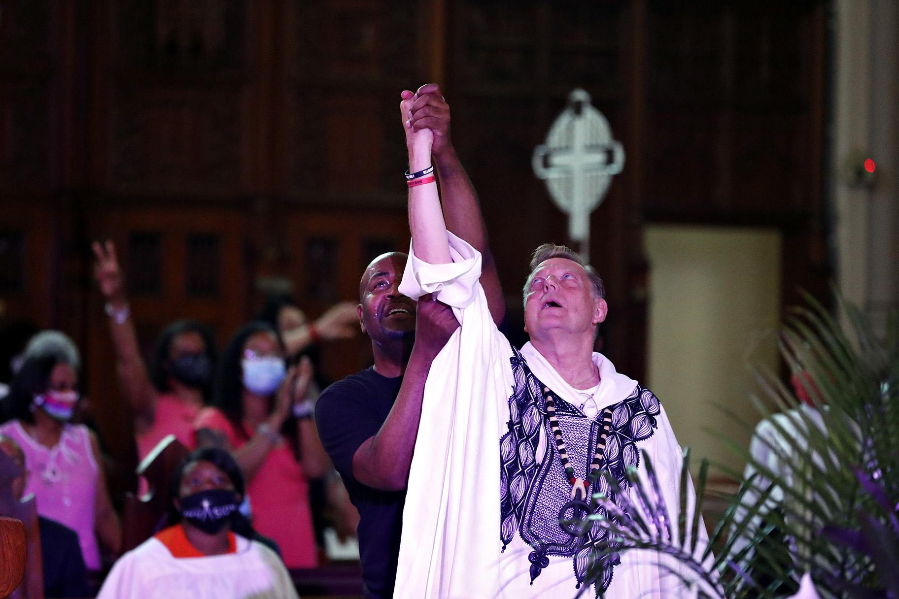 A parishioner raises Rev. Michael Pfleger’s arm as he conducts his first Sunday church service as a senior pastor at St. Sabina Catholic Church following his reinstatement by Archdiocese of Chicago after decades-old sexual abuse allegations against minors, Sunday, June 6, 2021, in the Auburn Gresham neighborhood in Chicago. (AP Photo / Shafkat Anowar)