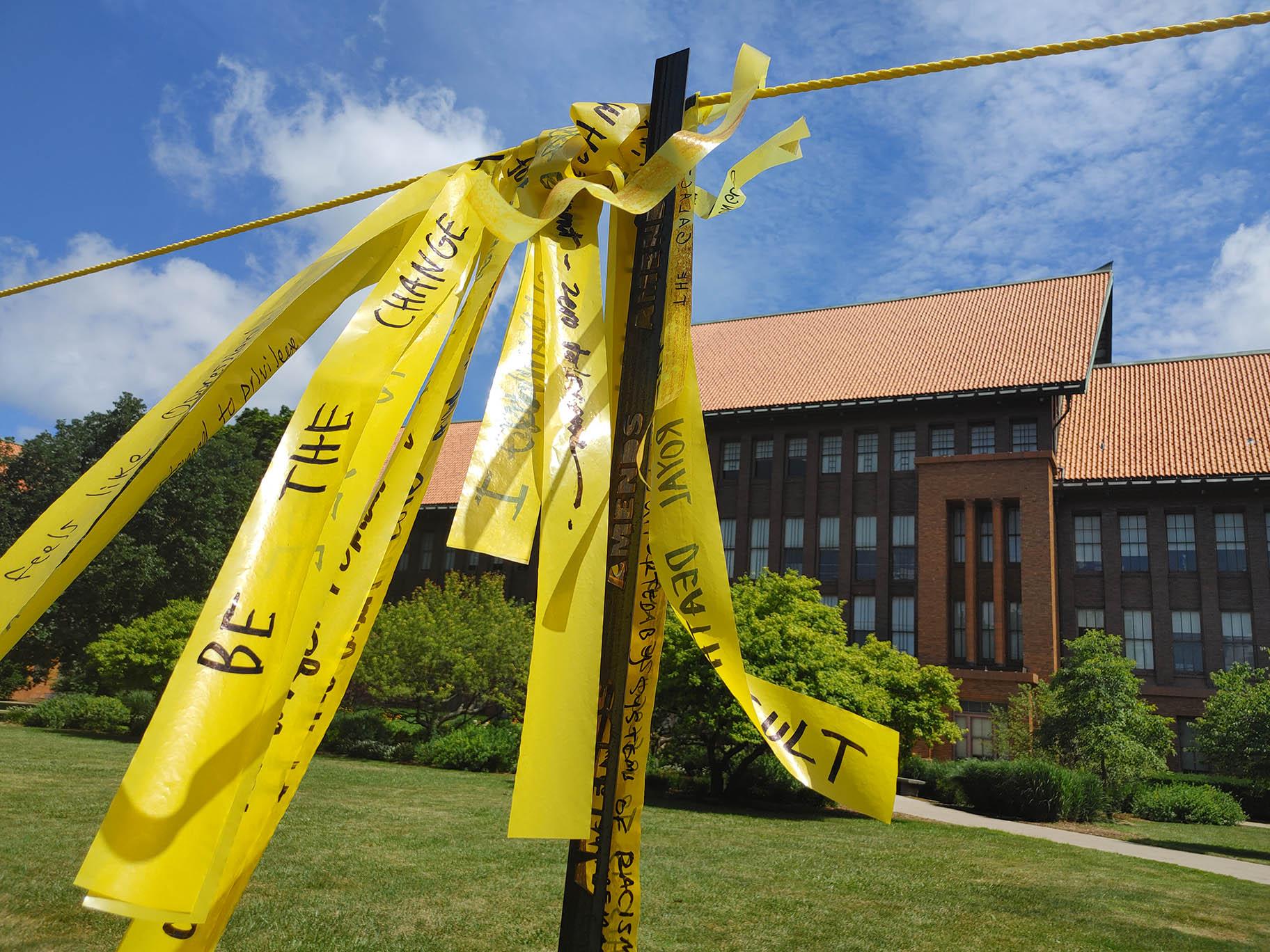 Handwritten messages on yellow ribbon comprise “Dirty Laundry” on the lawn at Schurz High School. (Erica Gunderson / WTTW News)