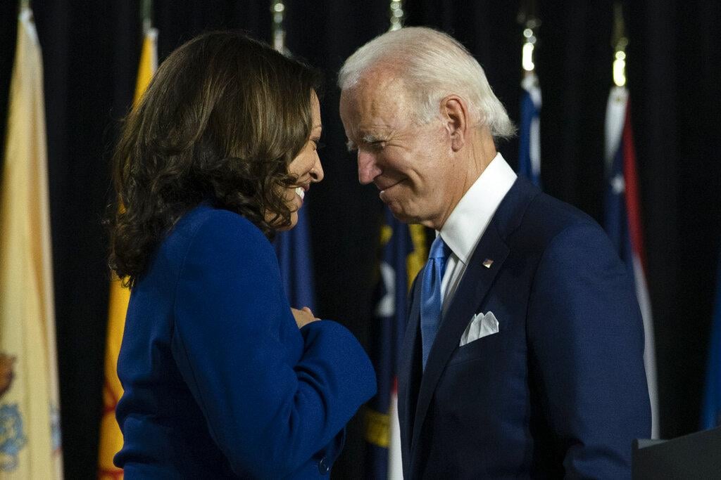 Democratic presidential candidate former Vice President Joe Biden and his running mate Sen. Kamala Harris, D-Calif., pass each other as Harris moves to the podium to speak during a campaign event at Alexis Dupont High School in Wilmington, Del., Wednesday, Aug. 12, 2020. (AP Photo / Carolyn Kaster)