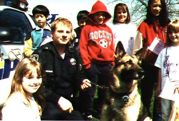 Former Oak Brook Police Officer Randy Mucha poses with K-9 Officer Marlo and a group of children. (Randy Mucha)