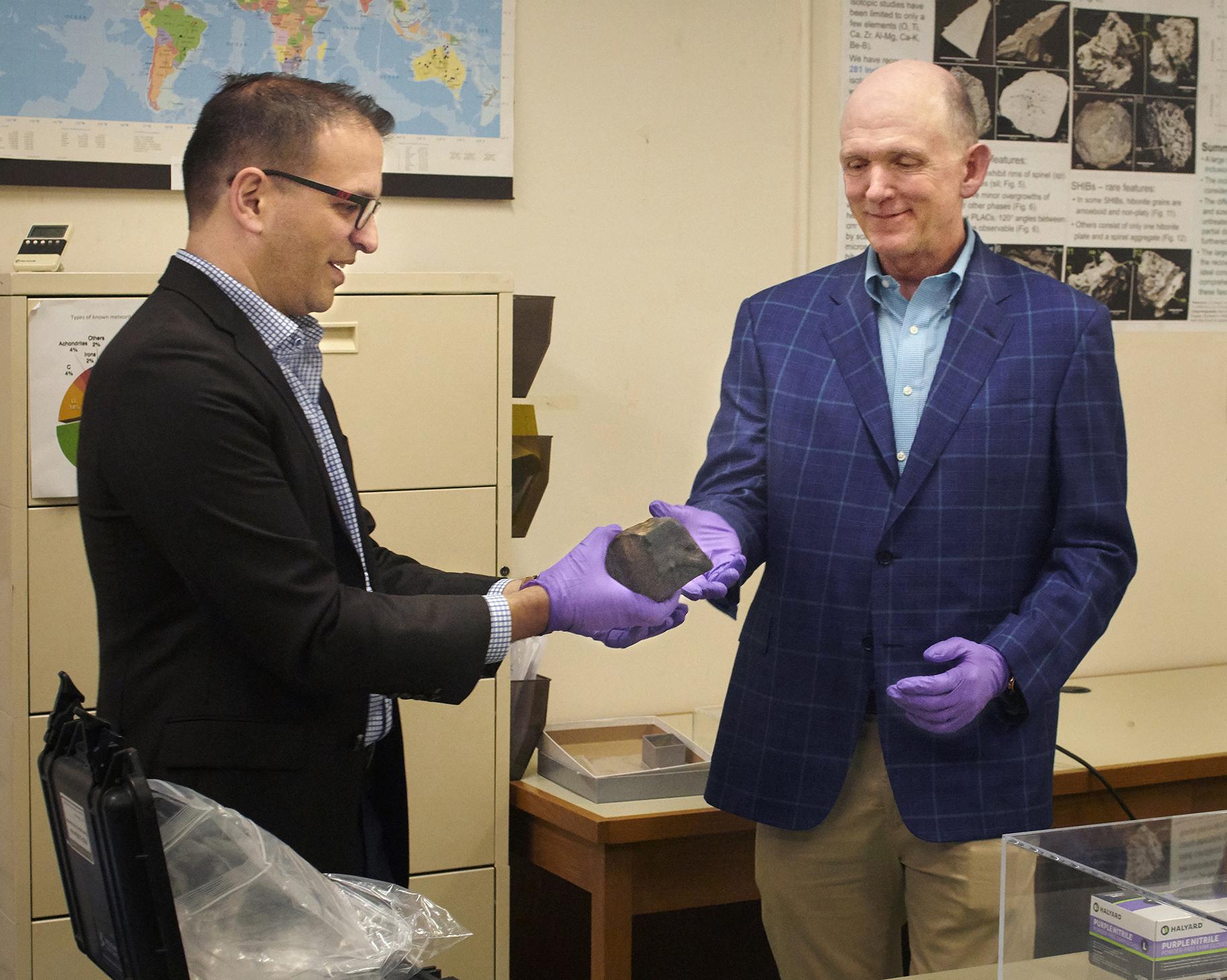 Field Museum donor Terry Boudreaux, right, holds the meteorite along with Philipp Heck, the museum’s associate curator for meteoritics and polar studies. (John Weinstein / Field Museum) 