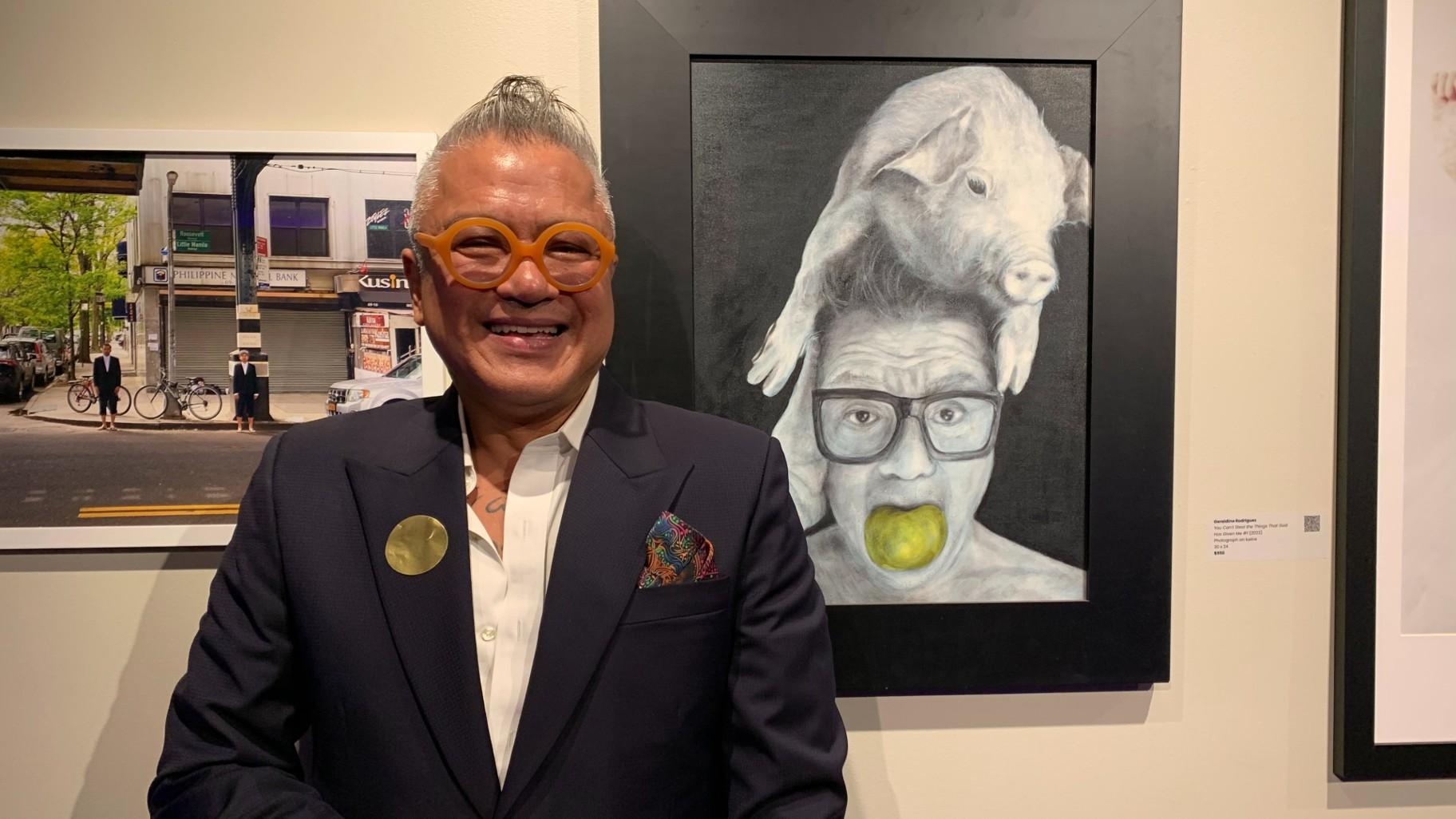 Artist and curator Cesar Conde with his artwork “Pig-Headed” at the “More than Lumpia” art exhibit on Oct. 6 at the Epiphany Center for the Arts. (WTTW News / Eunice Alpasan)