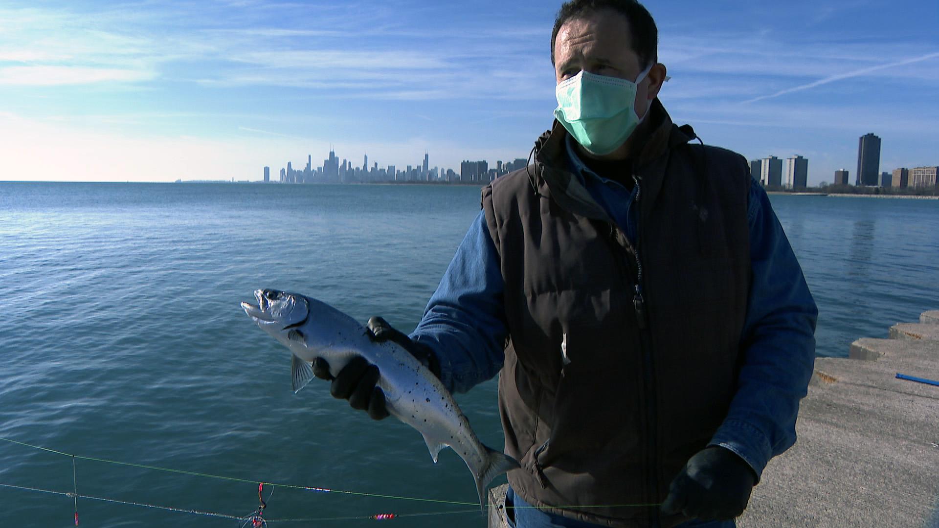 Florin Deleanu shows off a coho salmon he caught by powerline fishing. (WTTW News)