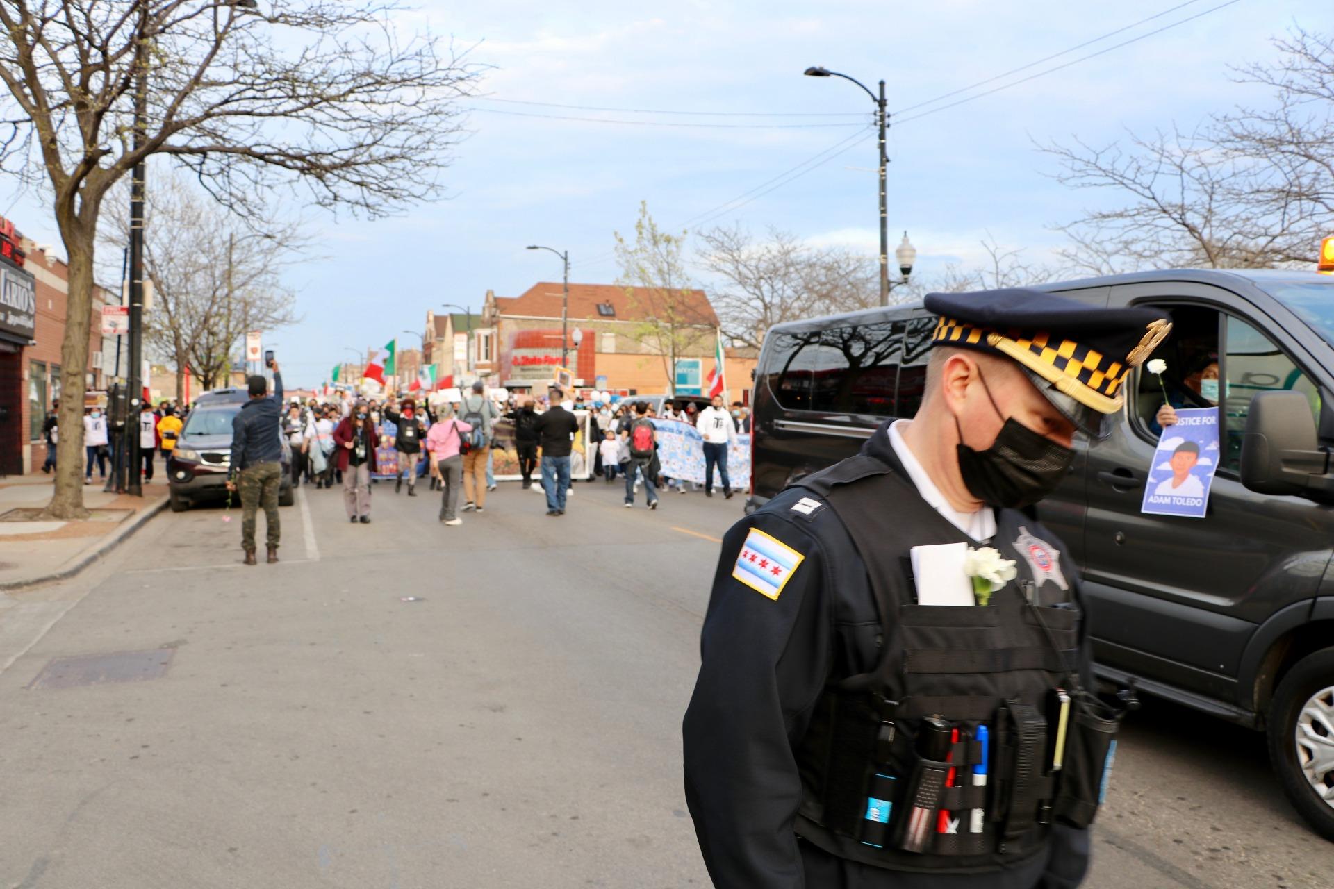 A police officer walks ahead of the march through Chicago’s Little Village neighborhood during the Adam Toledo peace walk on April 18, 2021. (Evan Garcia / WTTW News)