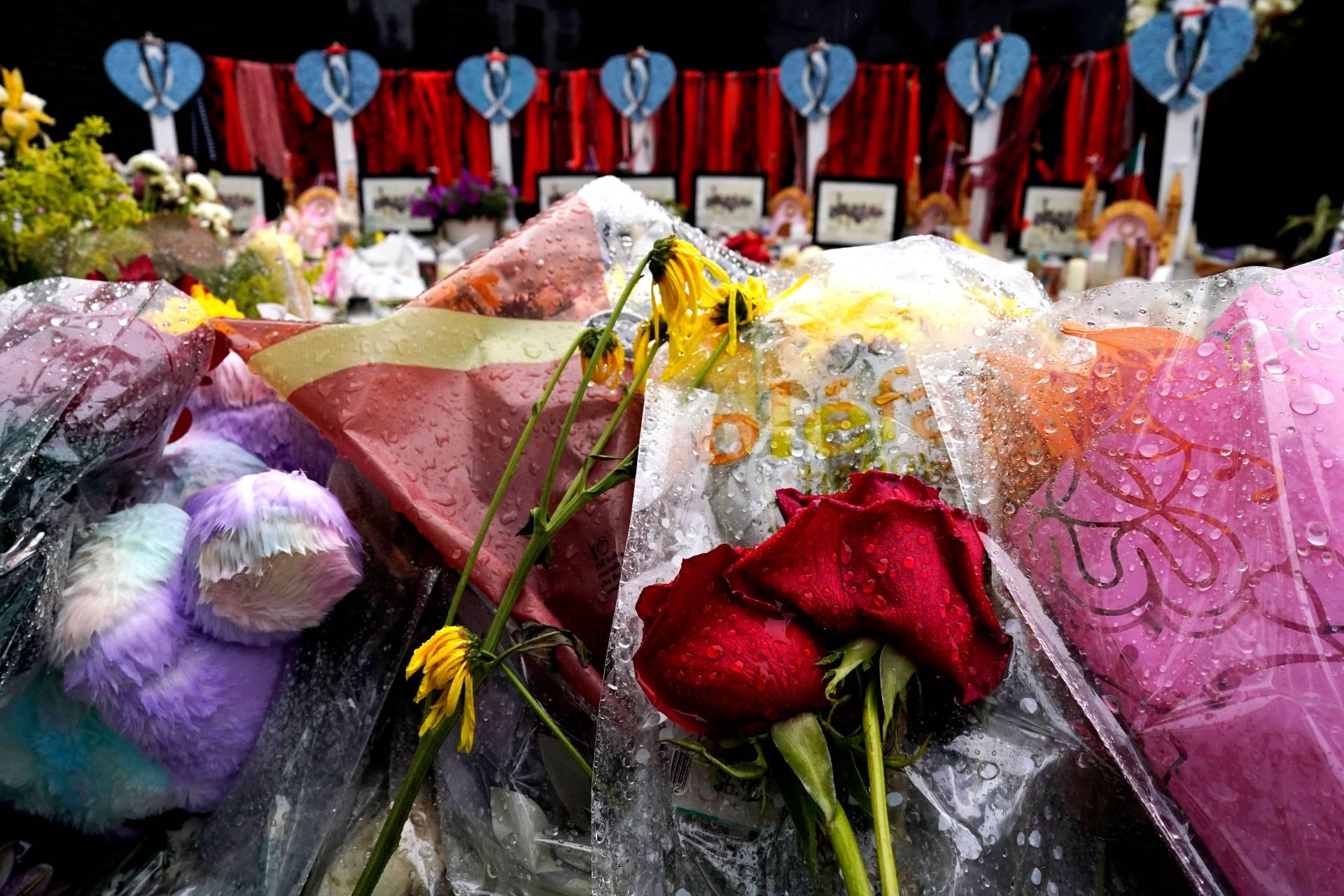 Wet flowers are seen during a rainy day at a memorial to the seven people killed and others injured in the Fourth of July mass shooting at the Highland Park War Memorial, Friday, July 15, 2022, in Highland Park, Ill. (AP Photo / Nam Y. Huh)