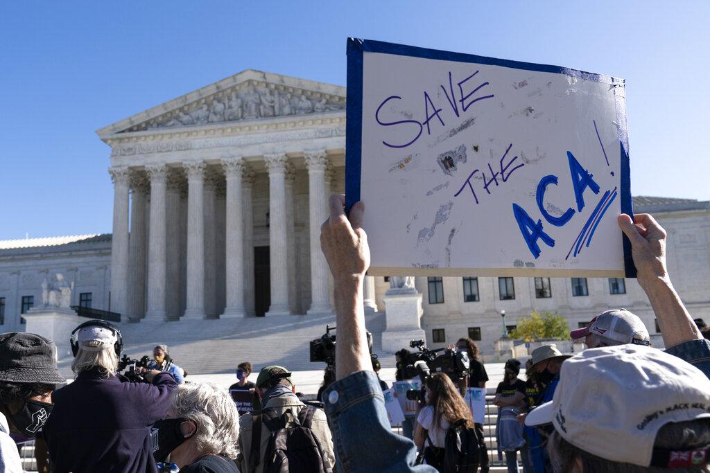 A demonstrator holds a sign in front of the U.S. Supreme Court as arguments are heard about the Affordable Care Act, Tuesday, Nov. 10, 2020, in Washington. (AP Photo / Alex Brandon)