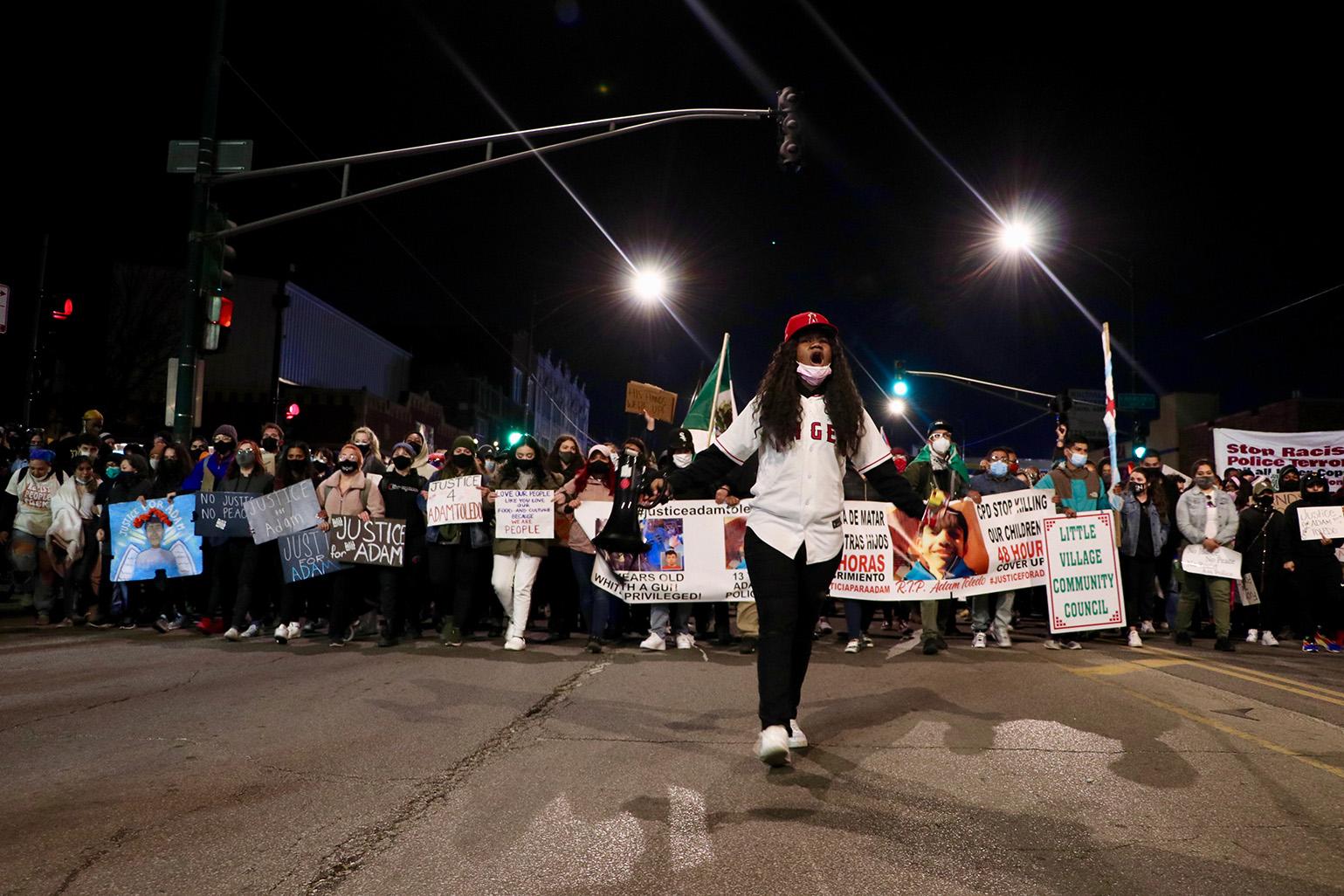 An organizer leads protesters along Fullerton Avenue April 16, 2021, during a protest over the fatal police shooting of 13-year-old Adam Toledo. (Evan Garcia / WTTW News)