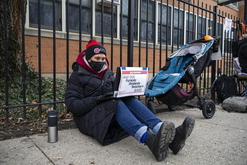 In this Jan. 11, 2021 file photo, a Suder Montessori Magnet Elementary School teacher speaks to students during a virtual class outside of the school in solidarity with pre-K educators forced back into the building in Chicago. (Anthony Vazquez / Chicago Sun-Times via AP, File)