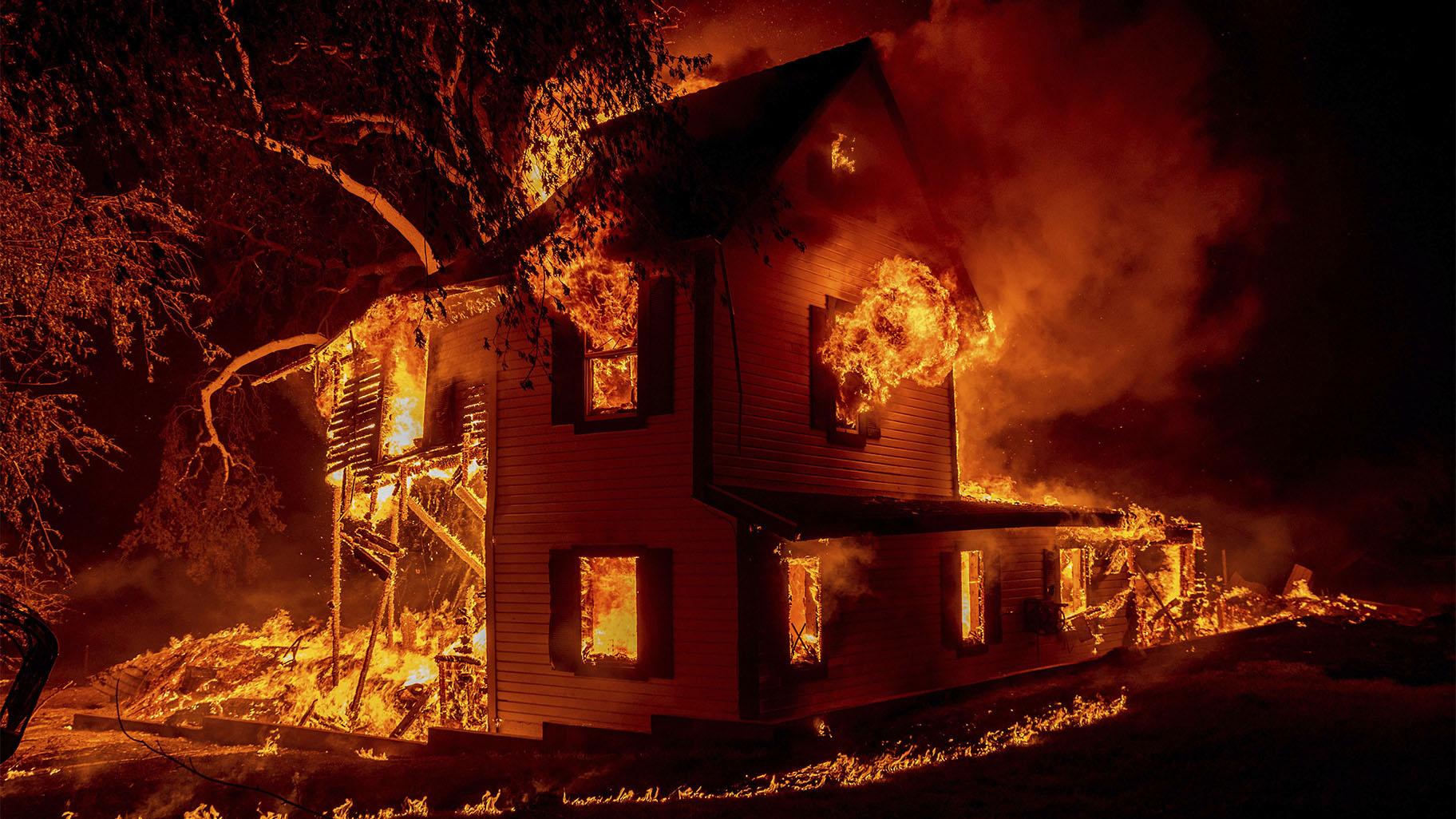 A home is engulfed in flames as the Dixie fire rages south of Janesville in Northern California, on Aug. 16, 2021. (AP Photo / Ethan Swope, File)