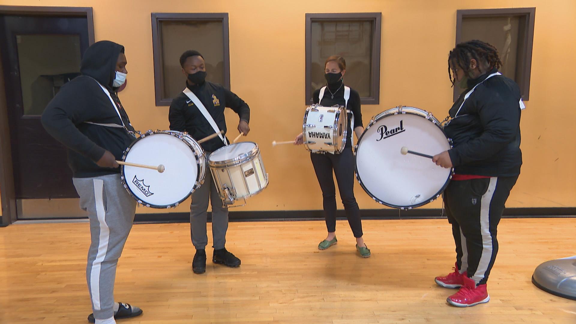 The drum line of BandWith rehearses inside the gymnasium of Marillac St. Vincent Family Services in East Garfield Park on Oct. 15, 2020. Snare drummer Marquis Allen, second to left, is the student instructor of the drum ensemble. (WTTW News)
