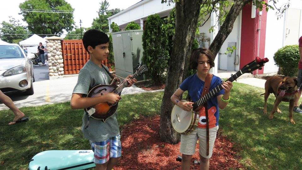 Kids try their thumbs at the art of the strum. (Frankfort Bluegrass Festival / Facebook)