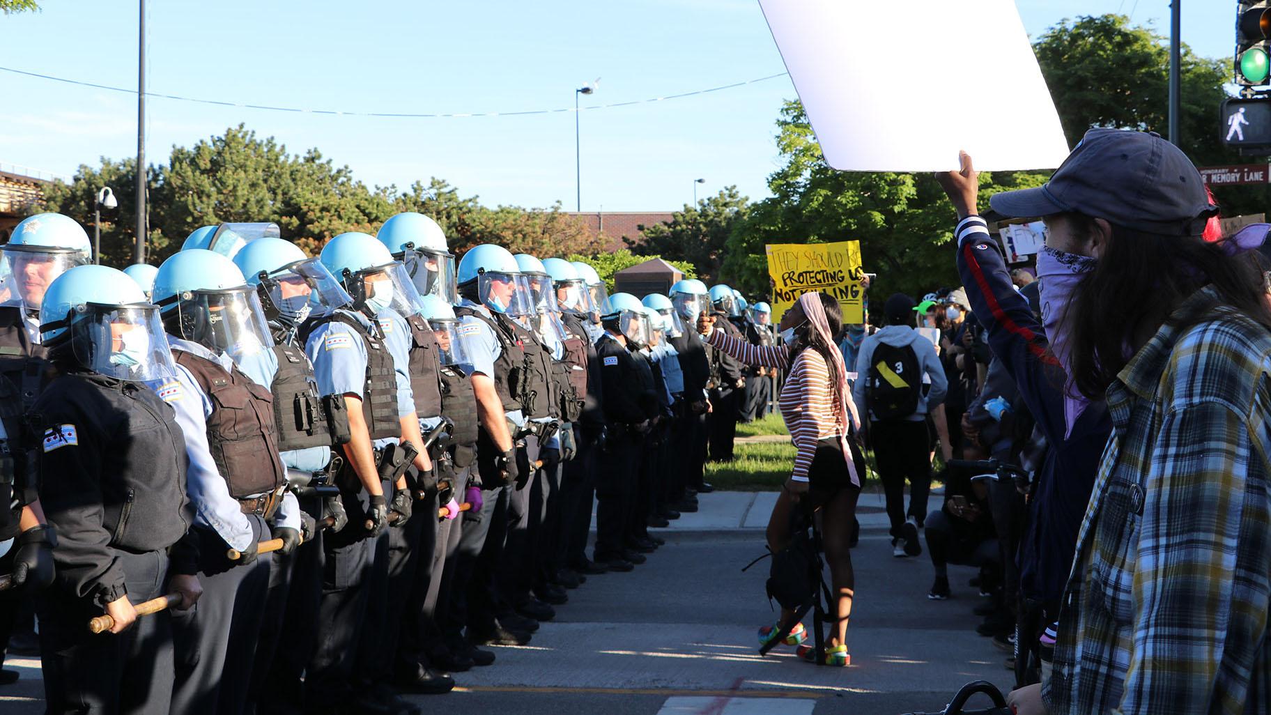 Protesters yell at a line of police officers at State and 35th streets, about 3 miles south of the Loop, where police set up a blockade on Sunday, May 31, 2020. (Evan Garcia / WTTW News)