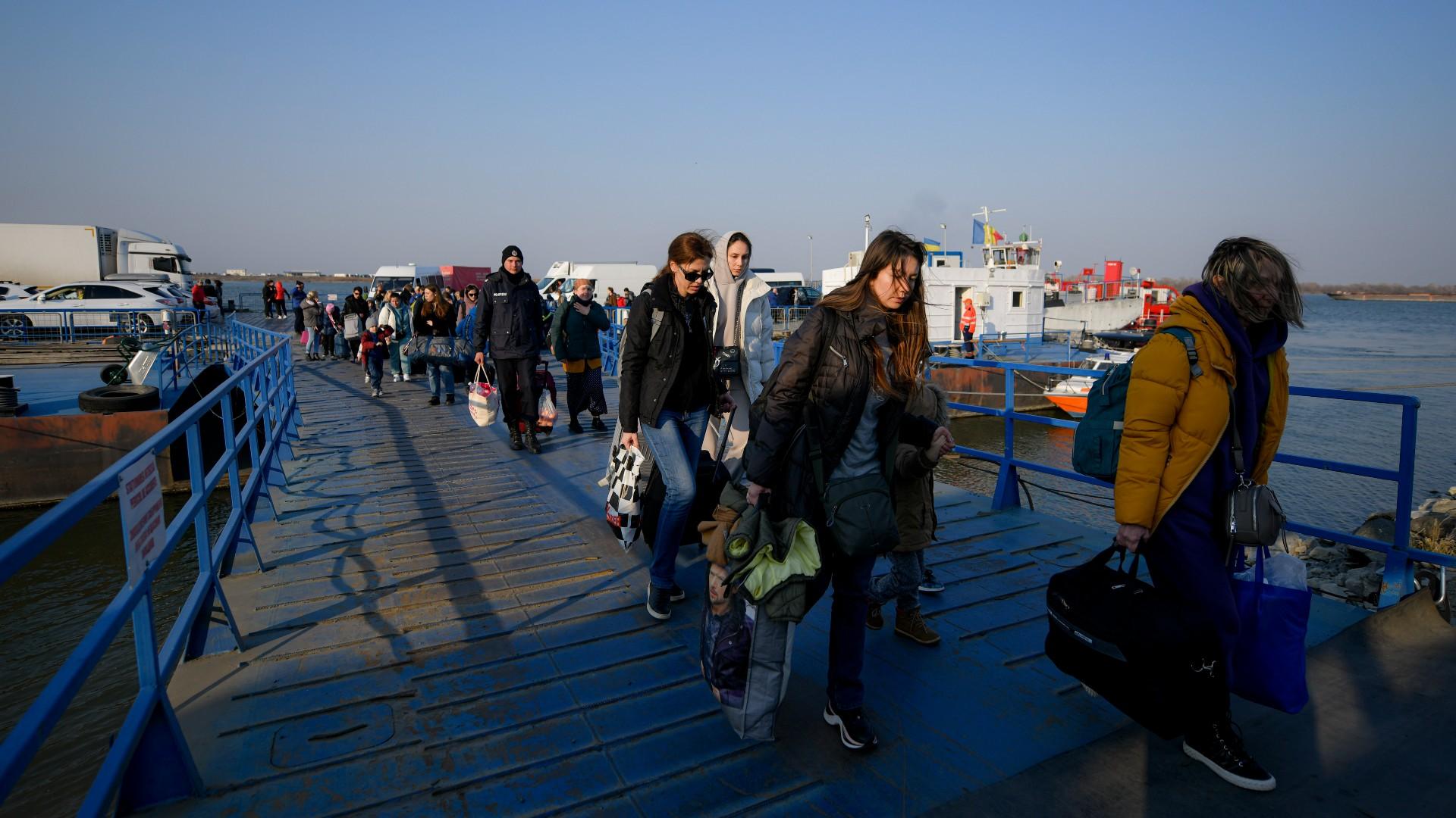 Refugees fleeing the war from neighboring Ukraine walk after crossing the border by ferry at the Isaccea-Orlivka border crossing in Romania, Thursday, March 24, 2022. (AP Photo / Andreea Alexandru)