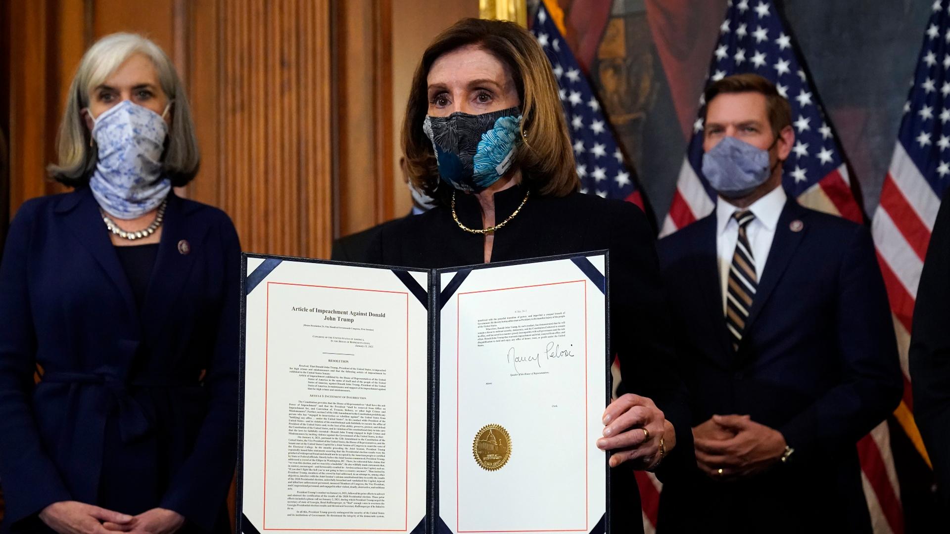 House Speaker Nancy Pelosi of Calif., displays the signed article of impeachment against President Donald Trump in an engrossment ceremony before transmission to the Senate for trial on Capitol Hill, in Washington, Wednesday, Jan. 13, 2021. (AP Photo / Alex Brandon)