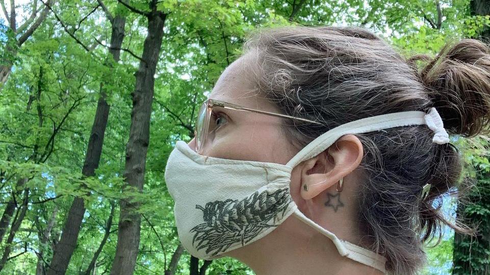 Artist Raychel Steinbach, wearing one of her own nature-inspired masks. (Current Location Press / Facebook)