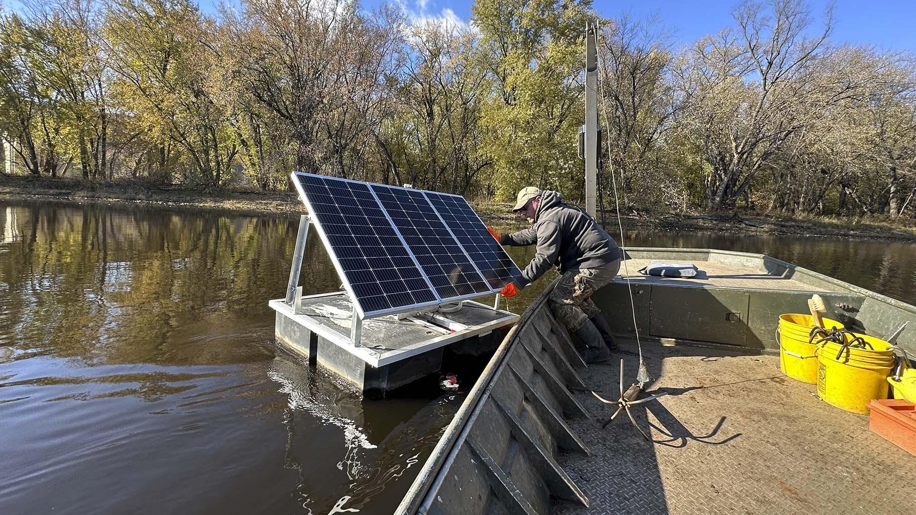 Minnesota Department of Natural Resources Fisheries Technician James Stone works to remove a floating solar-powered telemetry receiver from the Mississippi River backwaters near La Crosse, Wis. on Monday, Nov. 6, 2023. (AP Photo / Todd Richmond)
