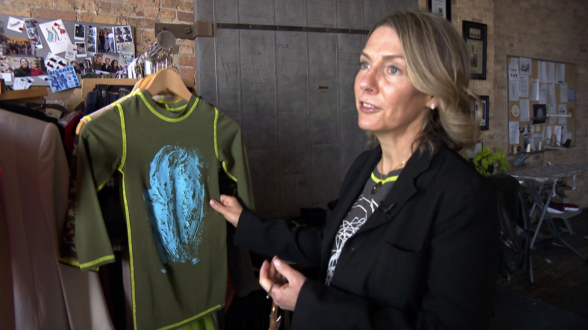 Minor Details founder Dina Lewis shows off her “squeeze tee,” designed to fit comfortably on children with sensory processing disorder, in her design studio on April 15, 2021. (WTTW News)