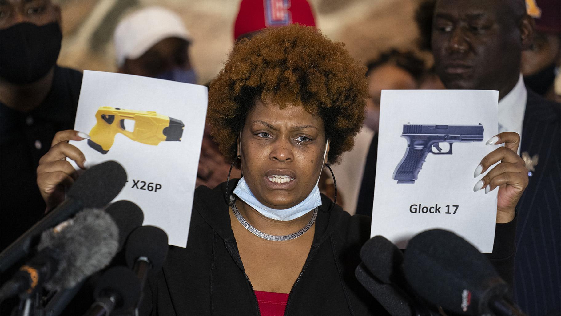 Naisha Wright, aunt of the deceased Daunte Wright, holds up images depicting X26P Taser and a Glock 17 handgun during a news conference at New Salem Missionary Baptist Church, Thursday, April 15, 2021, in Minneapolis. (AP Photo / John Minchillo)