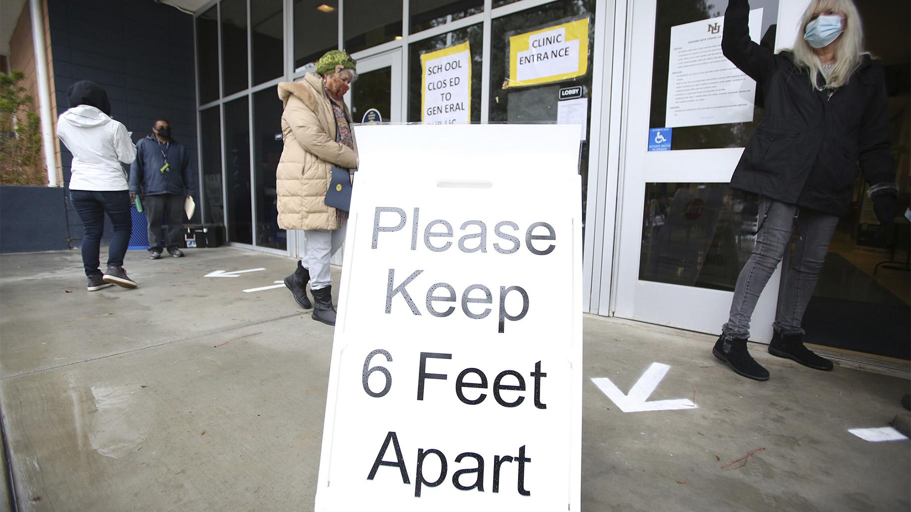 A sign asks those getting vaccinated to keep 6 feet apart during the vaccination event, Wednesday, Jan. 27, 2021, at Nevada Union High School in Grass Valley, Calif. (Elias Funez / The Union via AP, File)