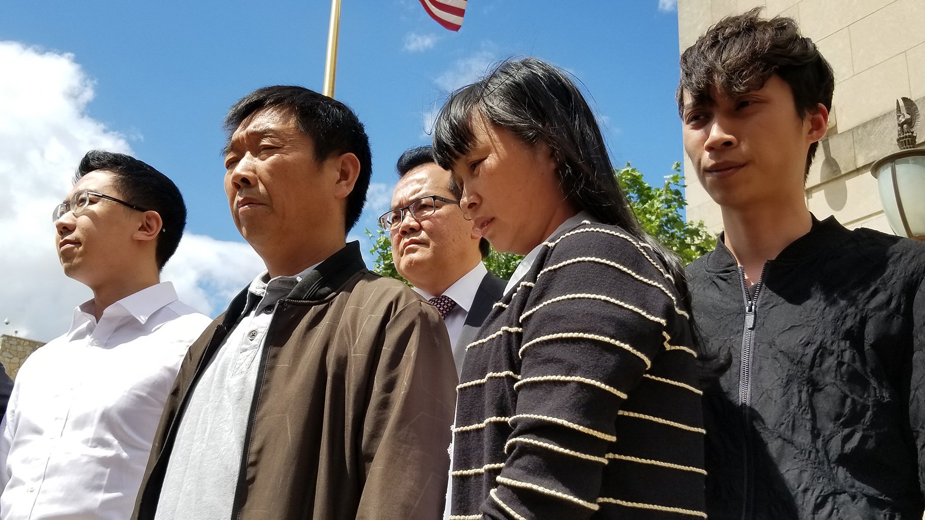 From left to right: Xiaolin Hou, Ronggao Zhang, Lifeng Ye and  Zhengyang Zhang stand outside the Peoria federal court building on June 24, 2019. (Matt Masterson / WTTW News)