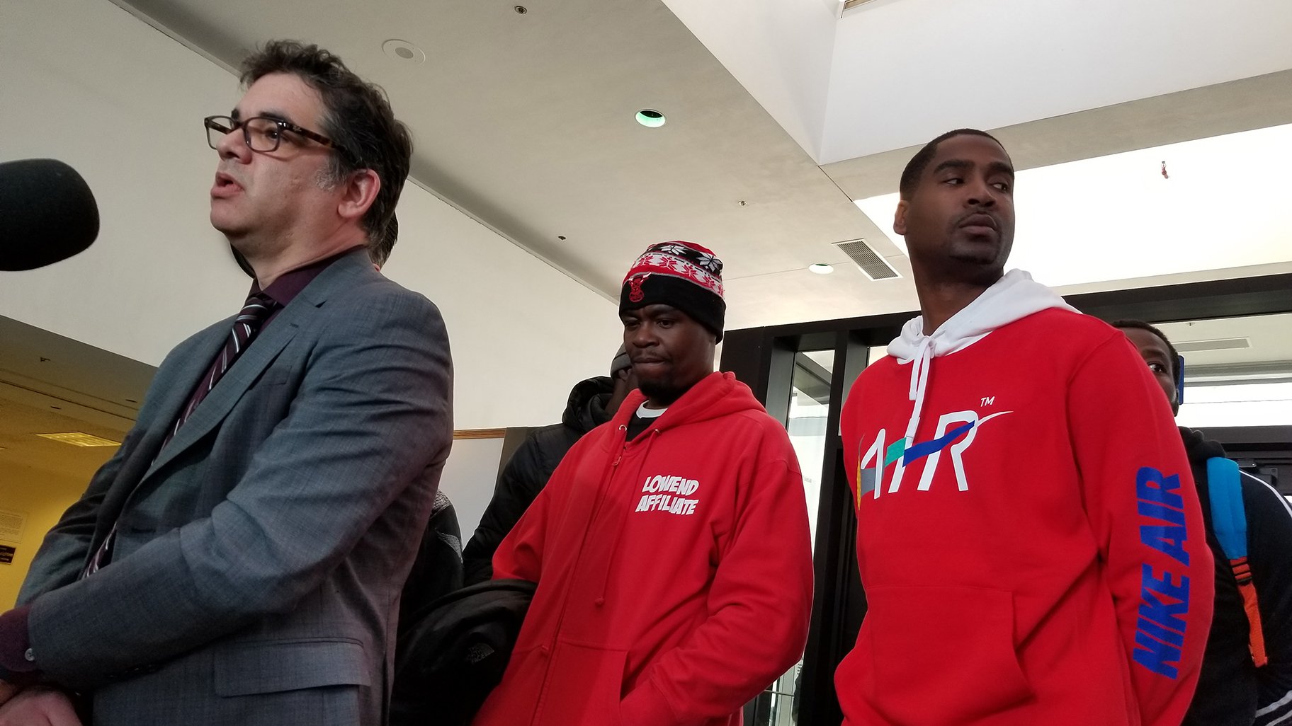 Attorney Josh Tepfer stands beside some of the men who had felony drug convictions vacated Tuesday during a hearing at the Leighton Criminal Court Building. (Matt Masterson / WTTW News)