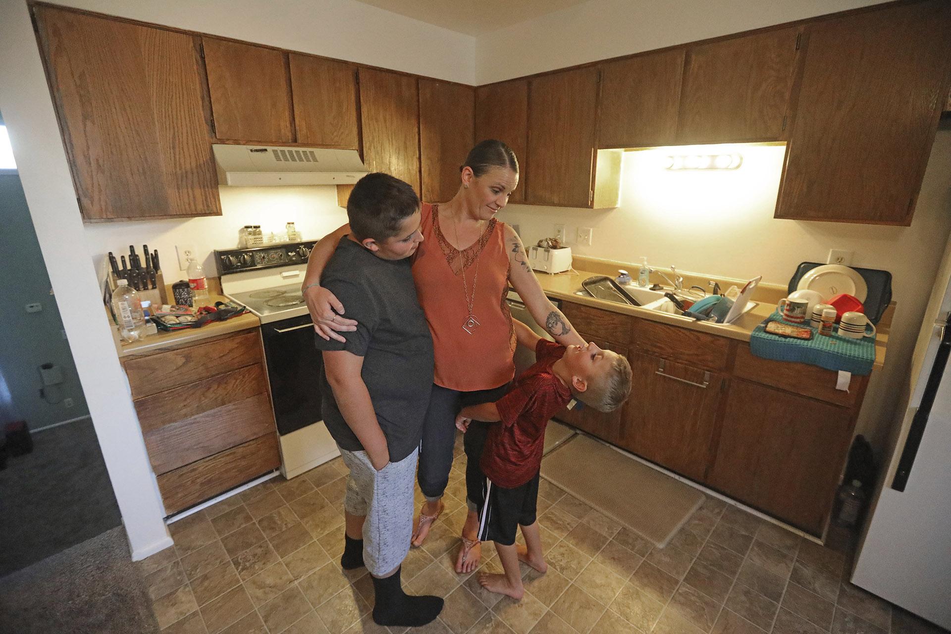 Misty Dotson hugs her son's at their home Tuesday, Aug. 20, 2019, in Murray, Utah. Dotson is a 33-year-old single mother of two boys, ages 12 and 6, who goes to Planned Parenthood for care through the Title X program. (AP Photo / Rick Bowmer)