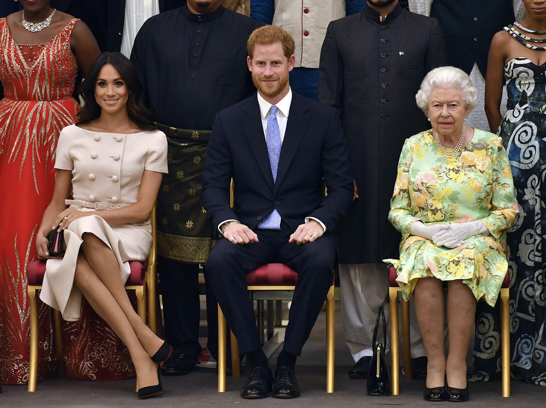 In this Tuesday, June 26, 2018 file photo, Britain’s Queen Elizabeth, Prince Harry and Meghan, Duchess of Sussex, pose for a group photo at the Queen’s Young Leaders Awards Ceremony at Buckingham Palace in London. (John Stillwell / Pool Photo via AP, File)