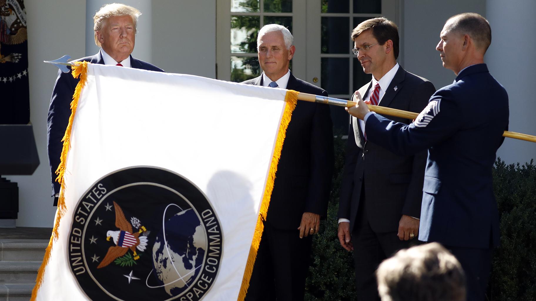 President Donald Trump watches with Vice President Mike Pence and Defense Secretary Mark Esper as the flag for U.S. Space Command is unfurled in the Rose Garden of the White House in Washington, D.C., on Thursday, Aug. 29, 2019. (AP Photo / Carolyn Kaster)