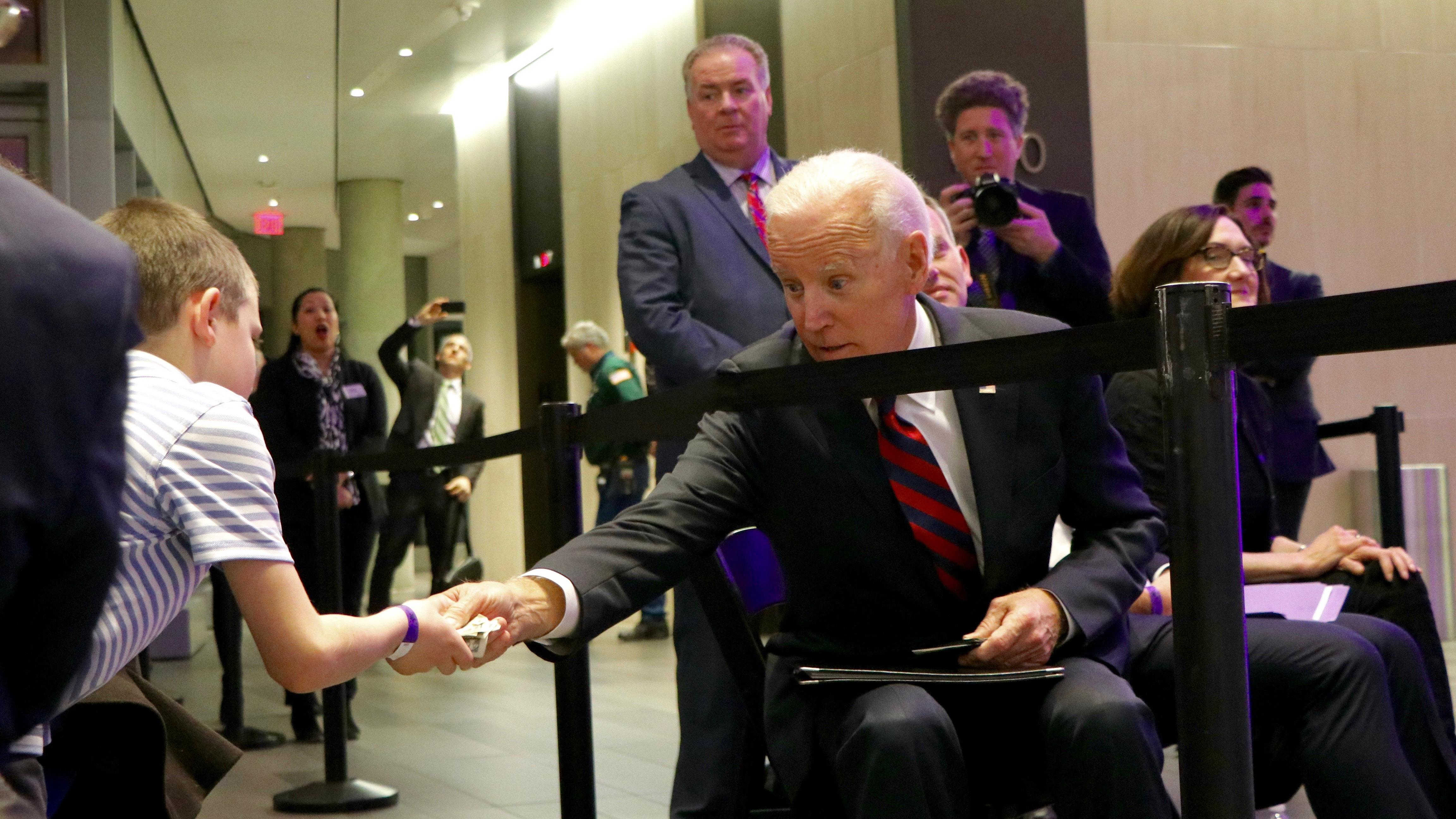 Biden hands a young attendee a few dollars after his speech. (Evan Garcia / Chicago Tonight)
