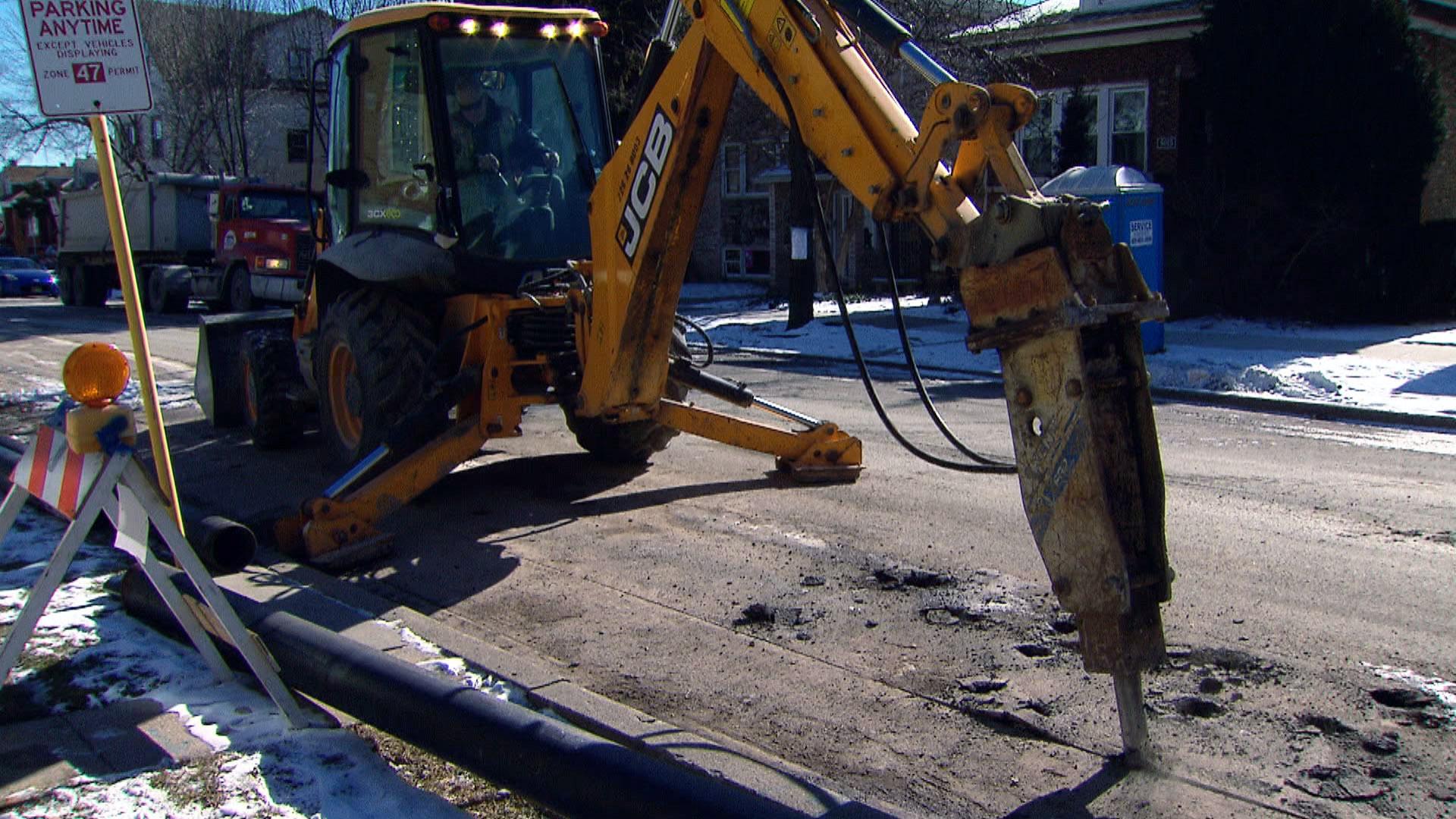 A crew replaces pipes beneath a residential street in Chicago. (WTTW News)