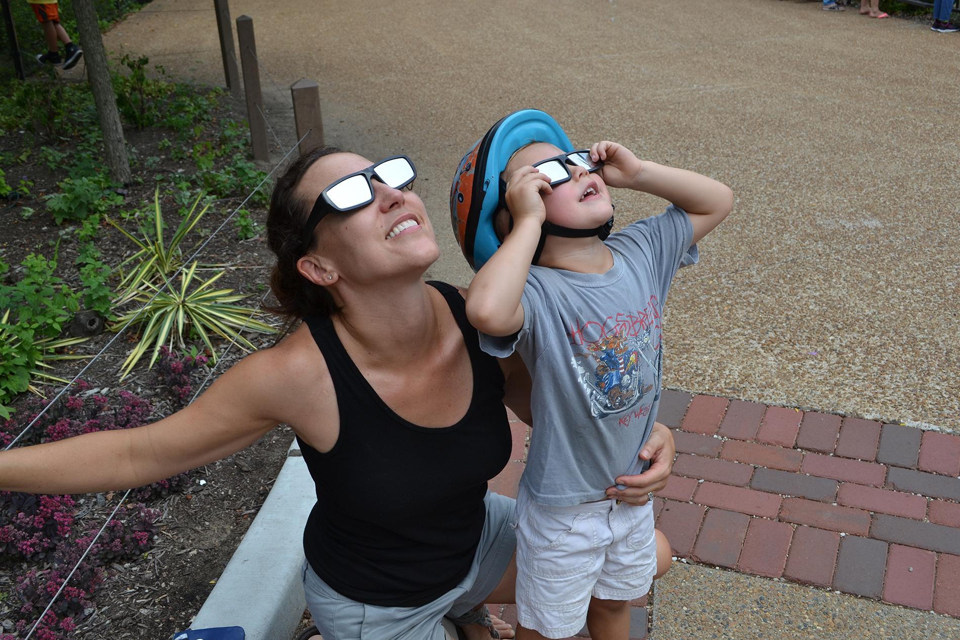 Maria Opdycke and her son, Simm, of Evanston, view the solar eclipse Monday at Lincoln Park Zoo. (Photos by Alex Ruppenthal / Chicago Tonight)