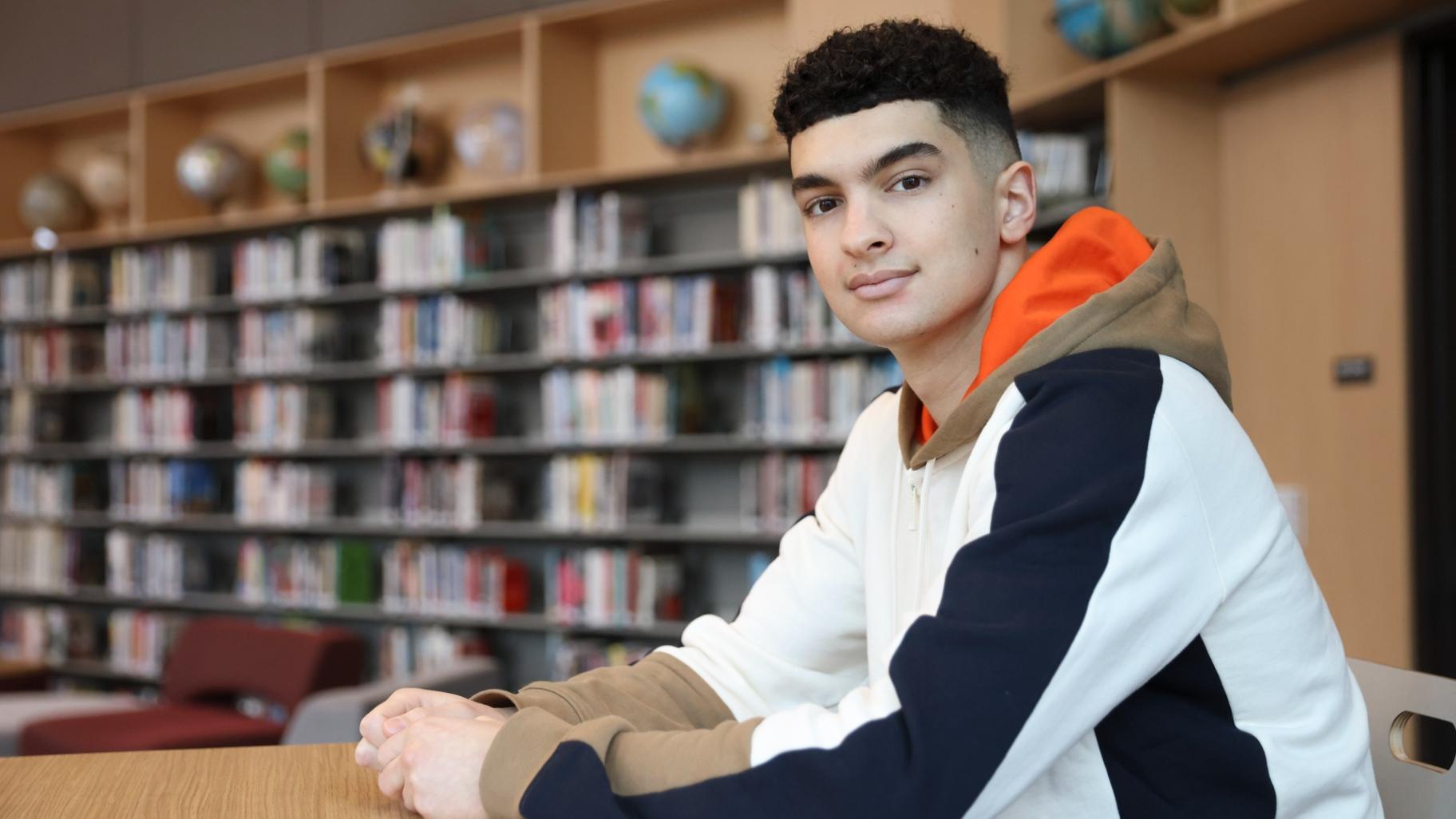Max Decker, a senior at Lincoln High School, sits for a portrait in the school library where he often worked on writing his college essays, in Portland, Ore., Wednesday, March 20, 2024. (Amanda Loman / AP Photo)