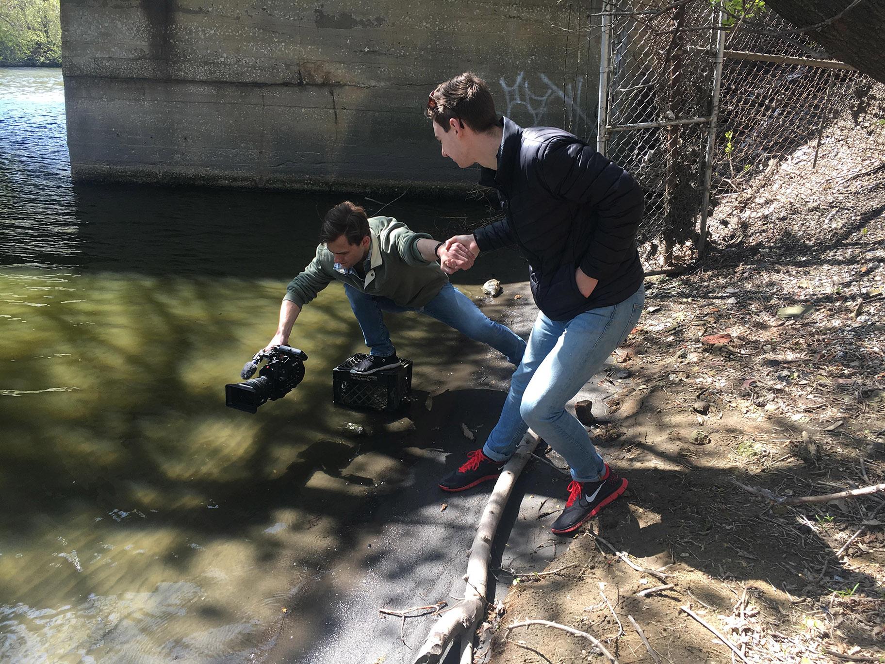 DePaul University student journalists shooting video of the bubbles in the creek. 