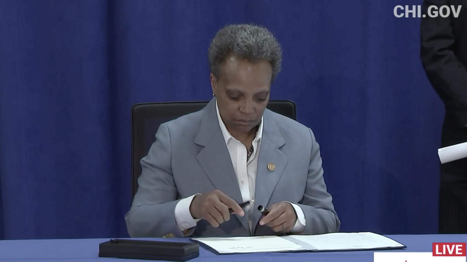 Mayor Lori Lightfoot signs an executive order ensuring all Chicago residents have equal access to COVID-19 aid programs regardless of citizenship status on Tuesday, April 7, 2020. (Chicago Mayor’s Office / Facebook photo)