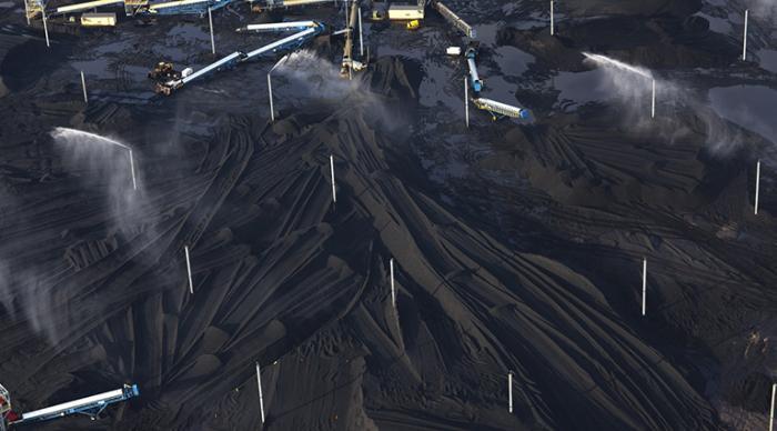 Petcoke piles with sprinklers at KCBX site on Calumet River, 2014. (Terry Evans / Courtesy of Museum of Contemporary Photography)